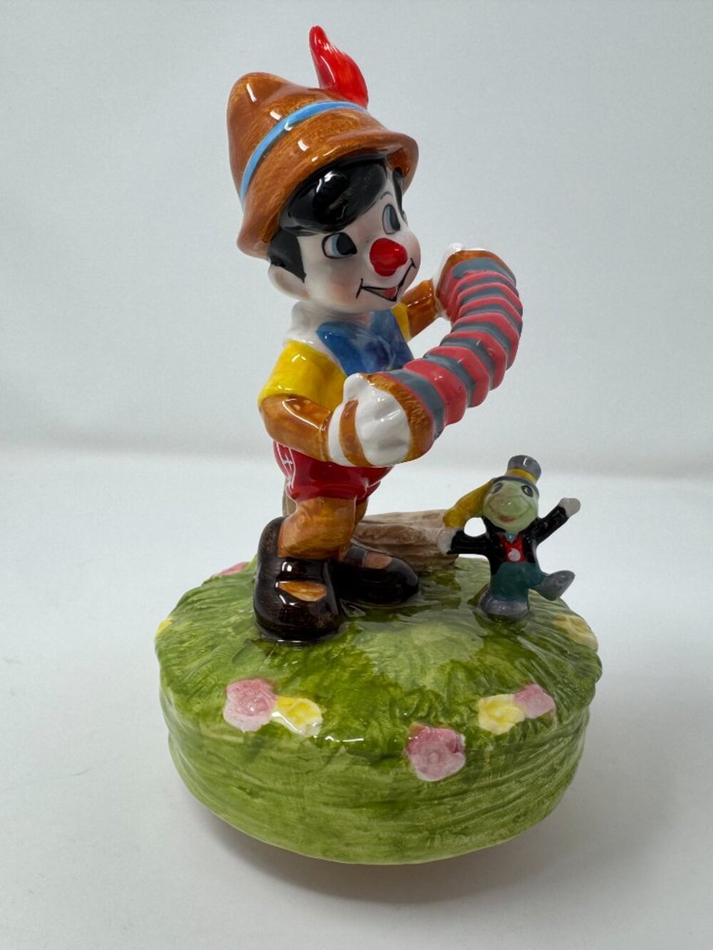 Vintage Walt Disney Productions music box featuring Pinocchio playing an accordi